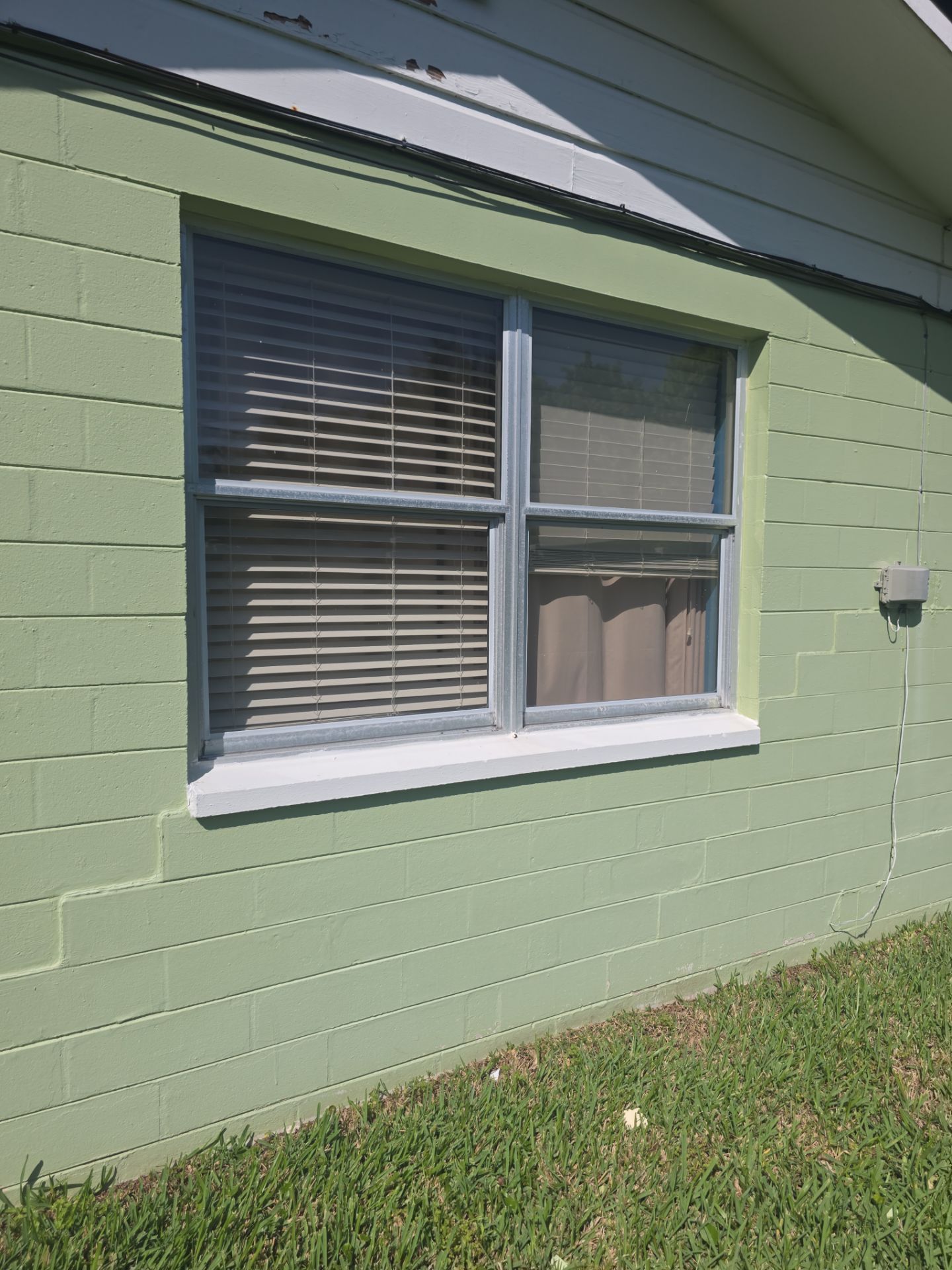 Before: Front elevation with new impact windows and impact entry door system.